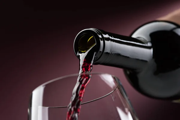 Pouring red wine into wineglass — Stock Photo, Image