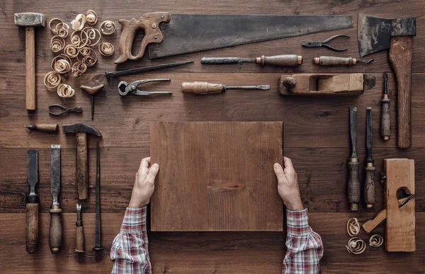 Carpintero sosteniendo un bloque de madera — Foto de Stock