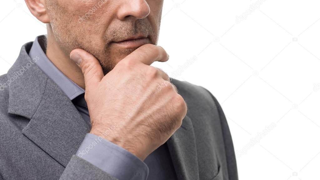 Pensive businessman with hand on chin