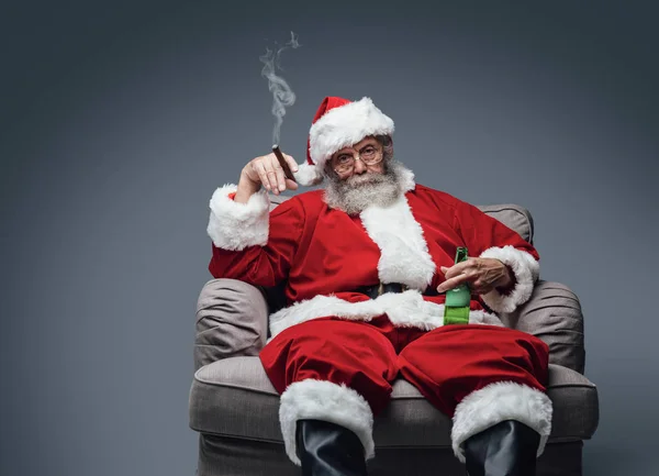 Санта курит сигару и пьет пиво — стоковое фото