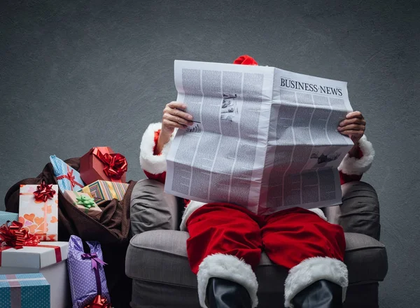 Santa Claus läsa ekonominyheter — Stockfoto