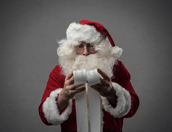 Weihnachtsmann prüft Einkaufsrechnungen — Stockfoto