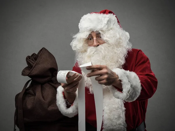 Papai Noel verificando contas de compras — Fotografia de Stock
