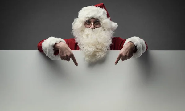 Weihnachtsmann zeigt auf leeres Schild — Stockfoto