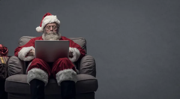 Papai Noel se conectando com um laptop — Fotografia de Stock