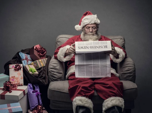 Santa Claus reading business news — Stock Photo, Image