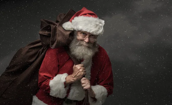 Santa Claus carrying Christmas gifts — Stock Photo, Image