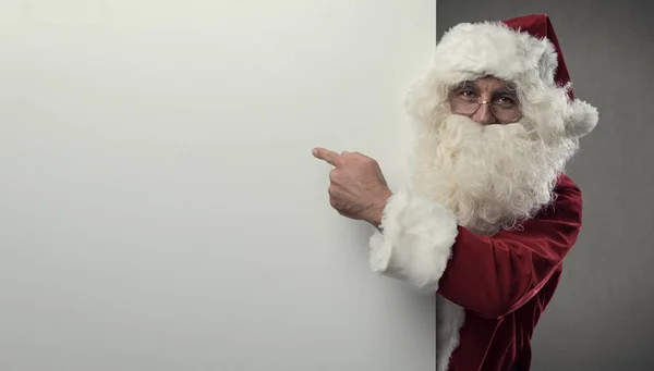 Papai Noel apontando para sinal em branco — Fotografia de Stock