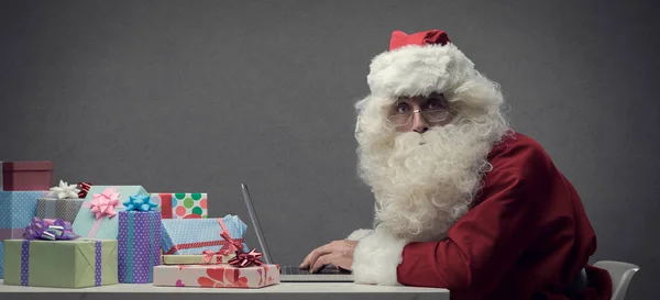 Papai Noel se conectando com seu laptop — Fotografia de Stock