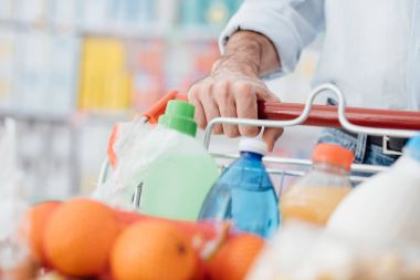 Bakkal yapan erkek süpermarkette alışveriş, o tam bir arabası zorlamıyor, el detay yakın çekim