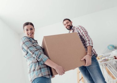 Yeni bir eve taşınma genç gülümseyen çift tam karton kutu taşıyorlar