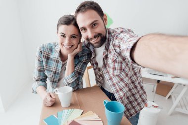 Onların yeni evime taşınmaya ve ev bir makyaj yapıyor genç çift gülümsüyor, onlar bir selfie alıyor