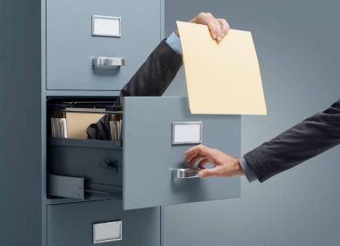 İşadamı içinde bir dosya için bir büro memuru veren bir dosya dolabı: hızlı dosya arama ve verimlilik kavramı