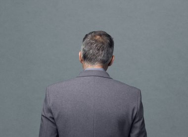 Arkadan Görünüm, gri bir arka plan ayakta işadamı