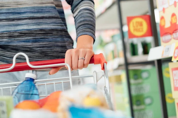 Ayrıntı yakın kadar yaşam kavramı el bakkal süpermarkette alışveriş ve tam bir alışveriş sepeti iterek yapıyor kadın