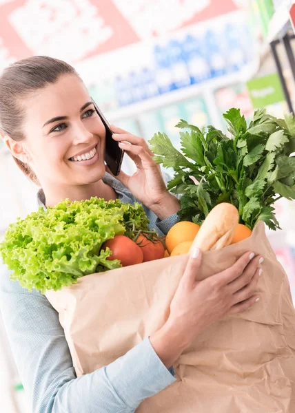 Красивая Молодая Женщина Делает Покупки Супермаркете Имеет Телефонный Звонок Держа — стоковое фото
