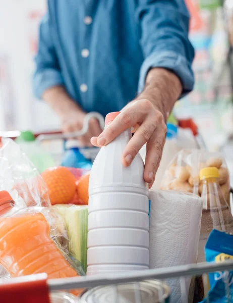 Man Gör Livsmedelsbutiker Shopping Stormarknaden Han Lägger Flaska Mjölk Kundvagnen — Stockfoto