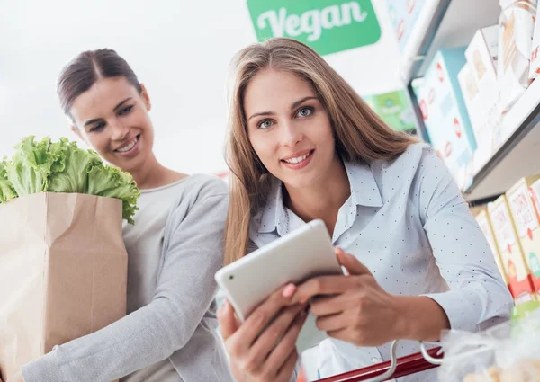 Jovens Mulheres Fazendo Compras Juntos Supermercado Uma Segurando Saco Com — Fotografia de Stock