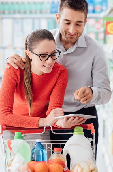Молодая Любящая Пара Делает Покупки Супермаркете Соединяются Цифровой Планшет Проверки — стоковое фото