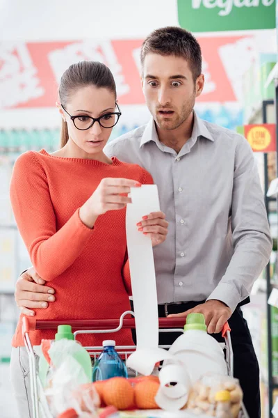 Giovani Coppie Shopping Supermercato Stanno Spingendo Carrello Controllando Una Lunga — Foto Stock