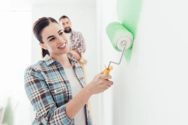 Young Cheerful Couple Renovating New House Woman Painting Paint Roller — Stock Photo, Image