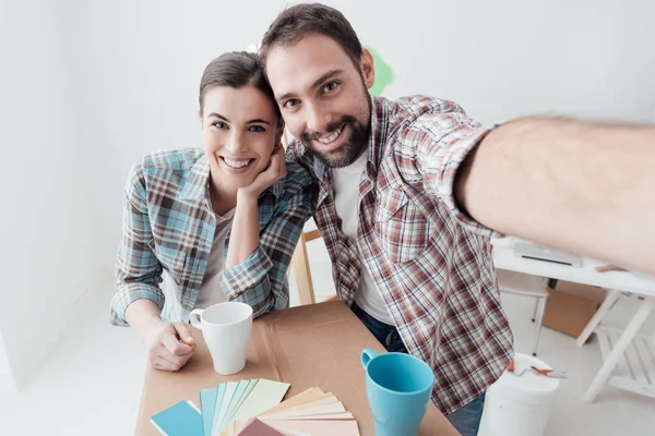 Onların yeni evime taşınmaya ve ev bir makyaj yapıyor genç çift gülümsüyor, onlar bir selfie alıyor