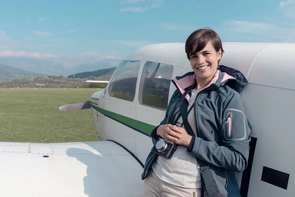 Lachende Vrouw Met Camera Poseren Luchthaven Leunend Tegen Een Propeller — Stockfoto