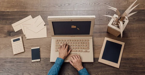 Karton, bir dizüstü bilgisayar, üstten görünüm yazmakta olduğunu yapılır yaratıcı çevre dostu bürosunda çalışan iş adamı