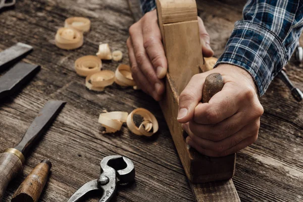 Carpinteiro Trabalhando Sua Oficina Ele Está Alisando Uma Tábua Madeira — Fotografia de Stock