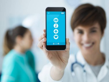 Gülümseyen kendine güvenen kadın doktor bir dokunmatik ekran smartphone ve sağlık personeli arka plan, tıbbi app kavramı holding
