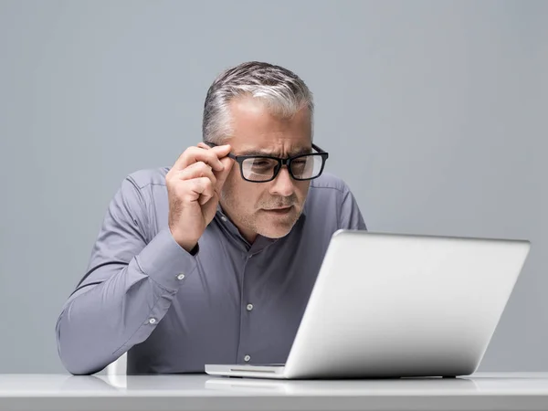 Зрелый Бизнесмен Работающий Ноутбуком Имеющий Проблемы Зрением Пристально Смотрит Экран — стоковое фото