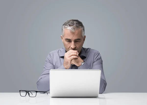 成熟したビジネスマンの机に座って 彼を読んで 考えて ノート パソコンで作業 ビジネス戦略 問題解決の概念 — ストック写真