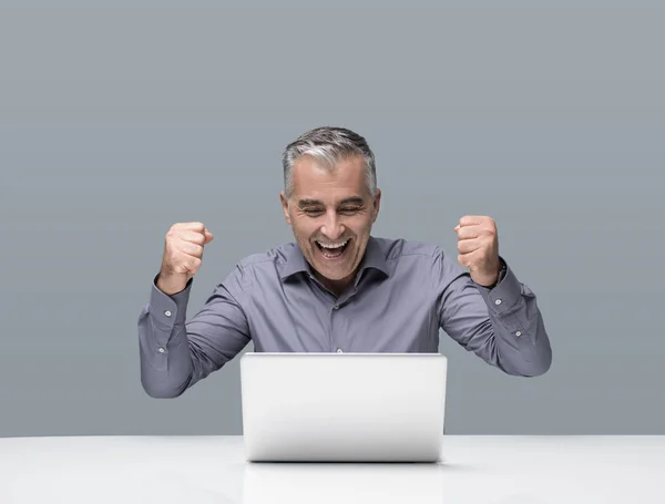 Веселый Зрелый Бизнесмен Работающий Рабочим Столом Ноутбуком Аплодирует Поднятыми Кулаками — стоковое фото