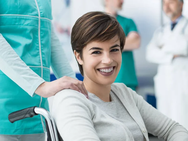 Lächelnde Junge Behinderte Patientin Krankenhaus Eine Krankenschwester Schiebt Ihren Rollstuhl — Stockfoto