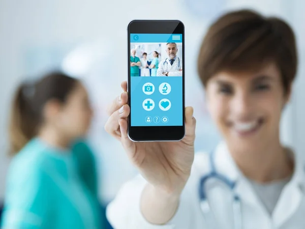 Smiling Confident Female Holding Touch Screen Smartphone Medical Staff Background — Stock Photo, Image