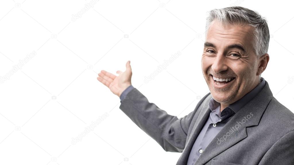 Welcoming businessman showing blank copy space and smiling at camera