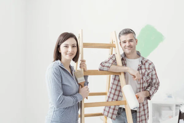 Usmívající se pár Malování domu — Stock fotografie