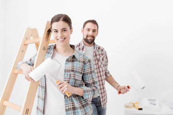 Happy couple painting new home