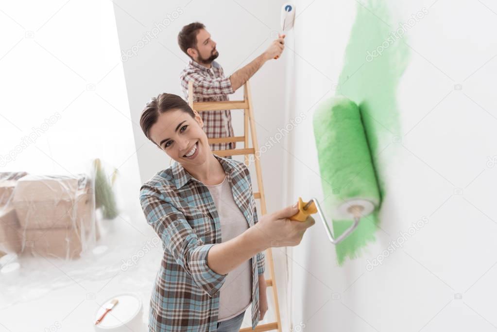 couple painting walls in new house