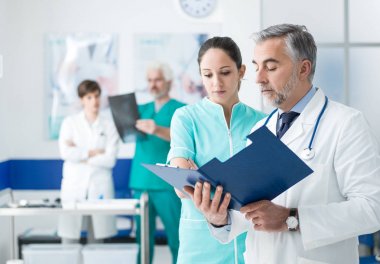Doktor ve hemşire tıbbi kayıtlarını incelemekle