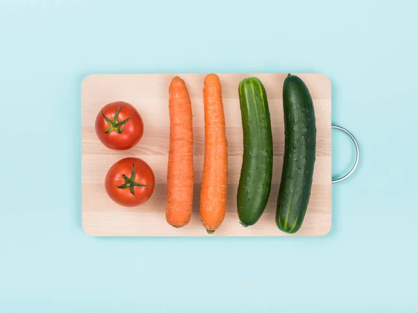 Produtos hortícolas orgânicos frescos sobre tábua de cortar — Fotografia de Stock