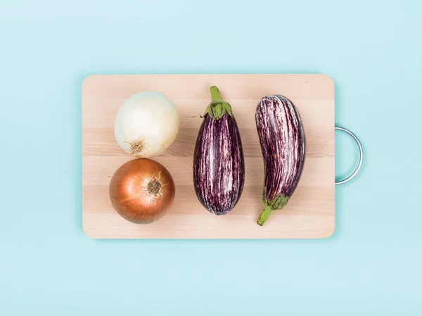 Uien en aubergines op hakken bestuur — Stockfoto