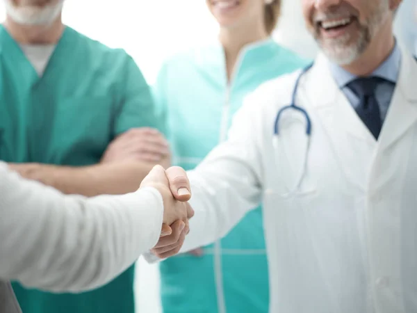 Confident doctor shaking patients hand — Stock Photo, Image