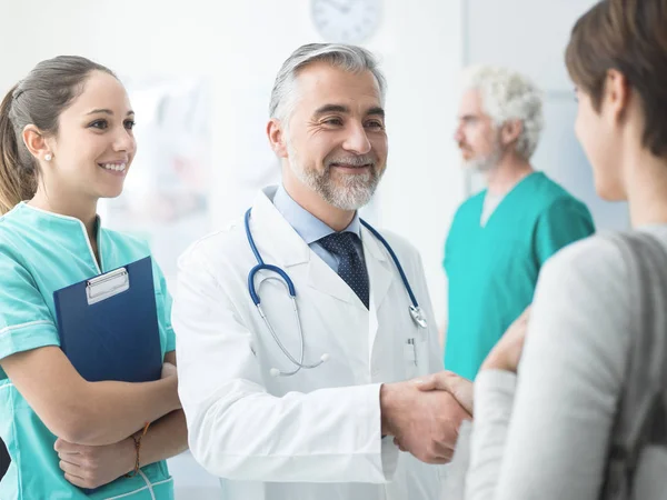 Médico sonriente estrechando la mano de los pacientes —  Fotos de Stock