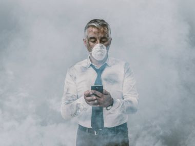 işadamı ile koruyucu maske smartphone kullanarak
