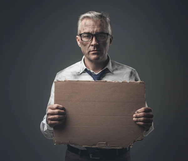 Бизнесмен с порванной картонкой вывеской — стоковое фото