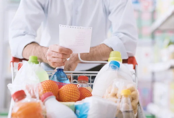 Man shopping med inköpslistan — Stockfoto