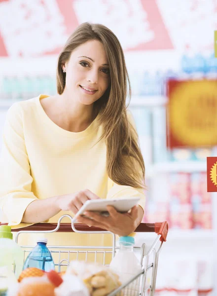 Junge Frau kauft im Supermarkt ein — Stockfoto