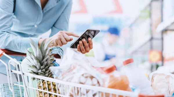 Woman doing grocery shopping at supermarket — Stock Photo, Image