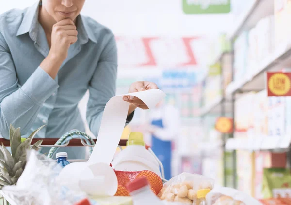 Mujer comprobando el recibo del supermercado —  Fotos de Stock